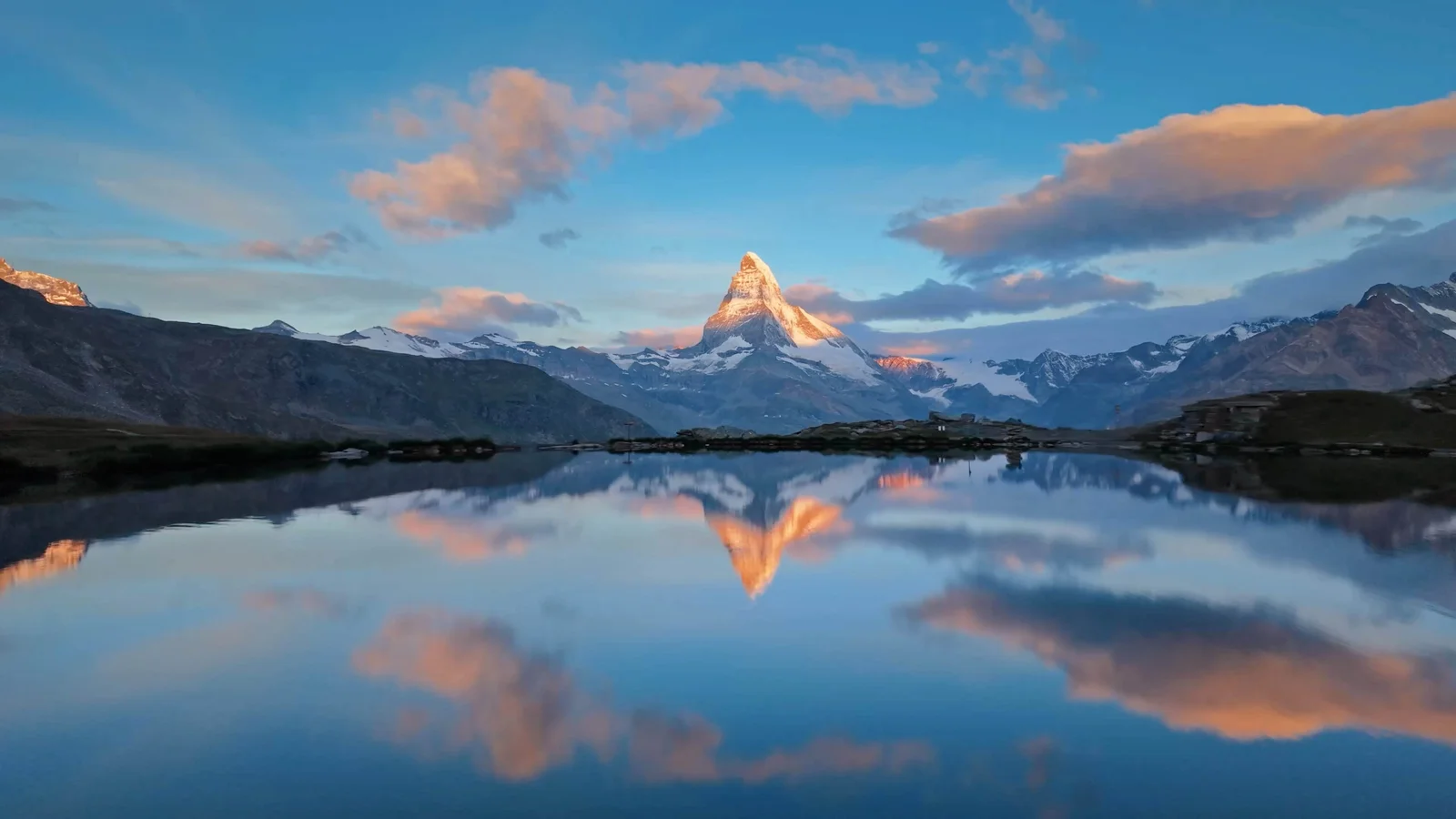 Alpengipfel im Spiegel eines stillen Sees bei Sonnenaufgang