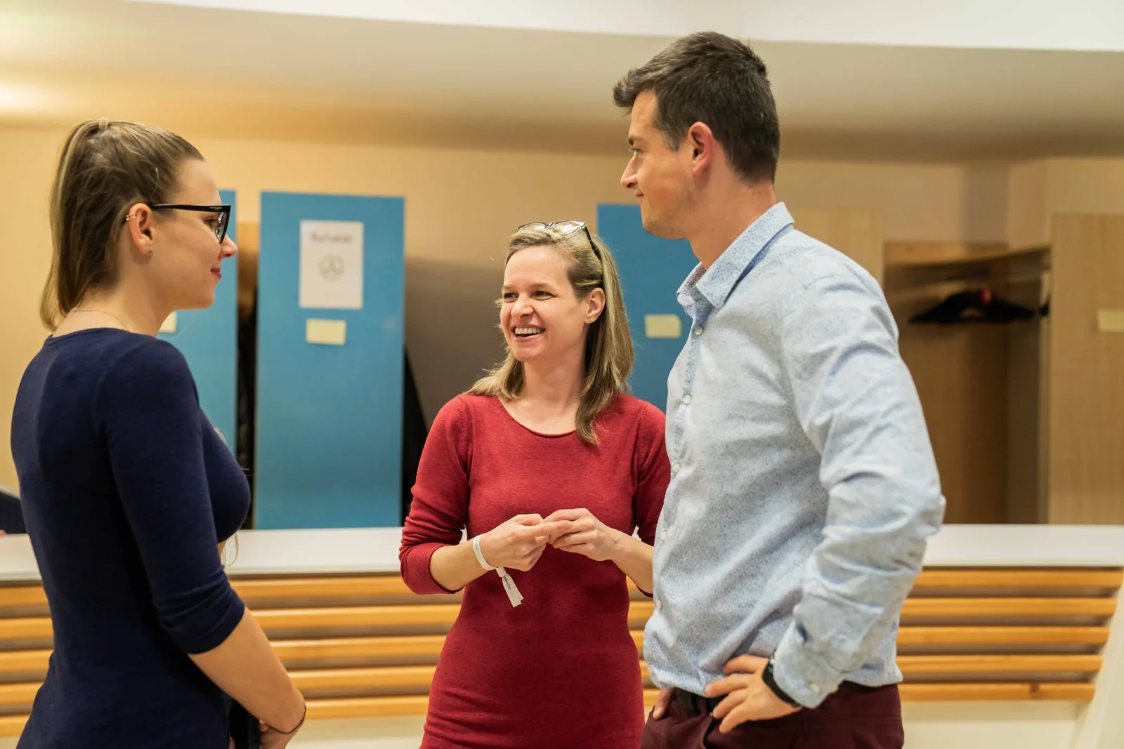Three attendees talk together between sessions.
