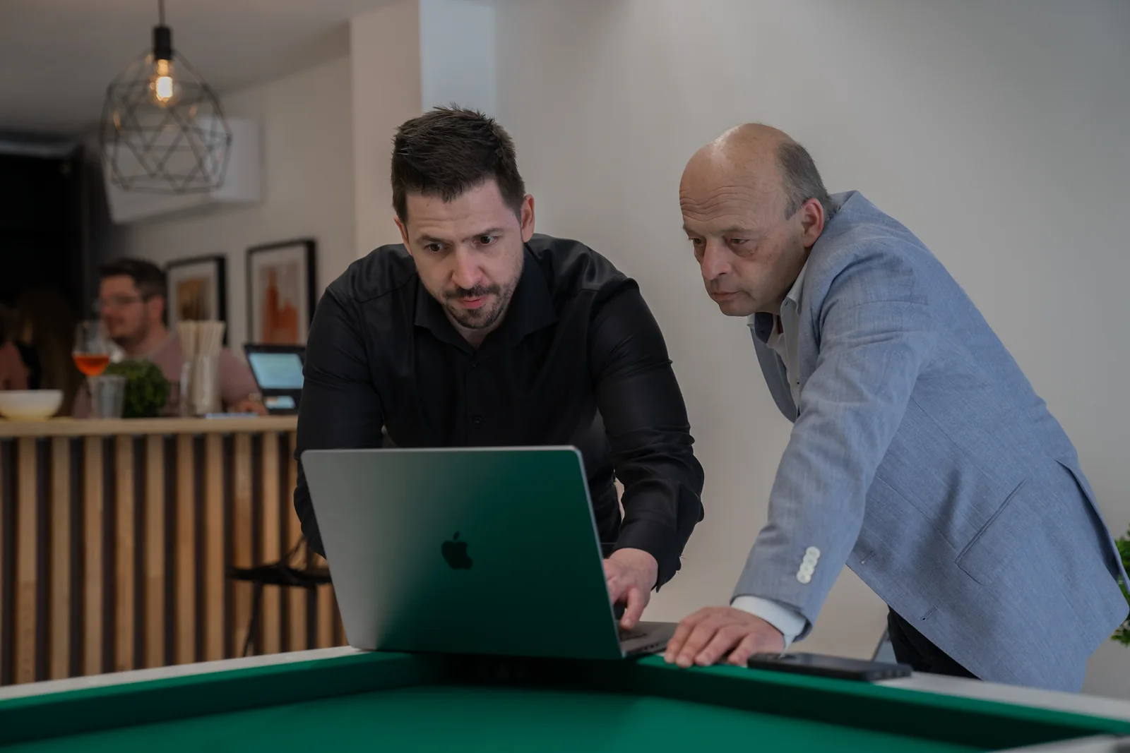 Két résztvevő együtt néz egy laptop képernyőjét.